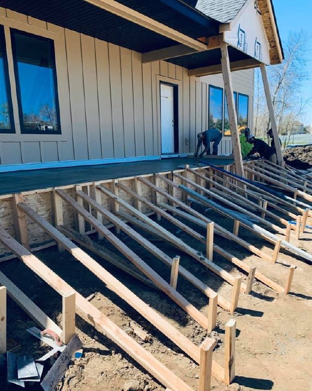 Raised wood framing and formwork beside a house