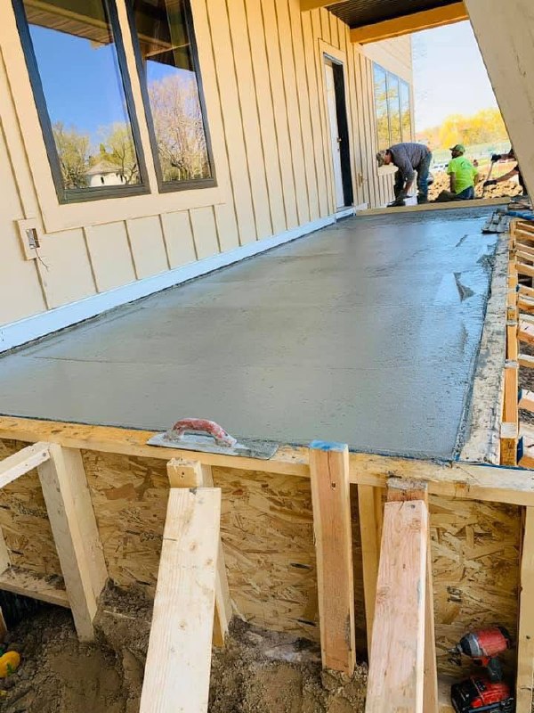 Freshly finished exterior concrete slab beside a building