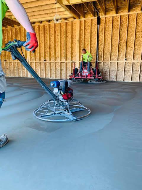 Close view of a power trowel finishing an interior concrete slab