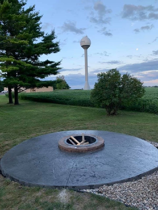 Circular stamped-concrete patio with a centered brick fire-pit ring